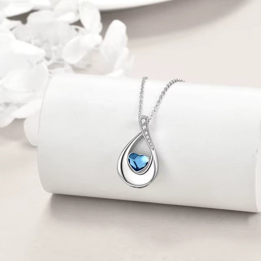 Sterling Silver Cremation necklace with a blue heart pendant on a white surface