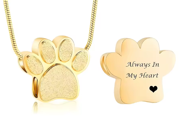 Gold paw print cremation necklace with engraved back reading Always In My Heart. Pet memorial keepsake jewelry.