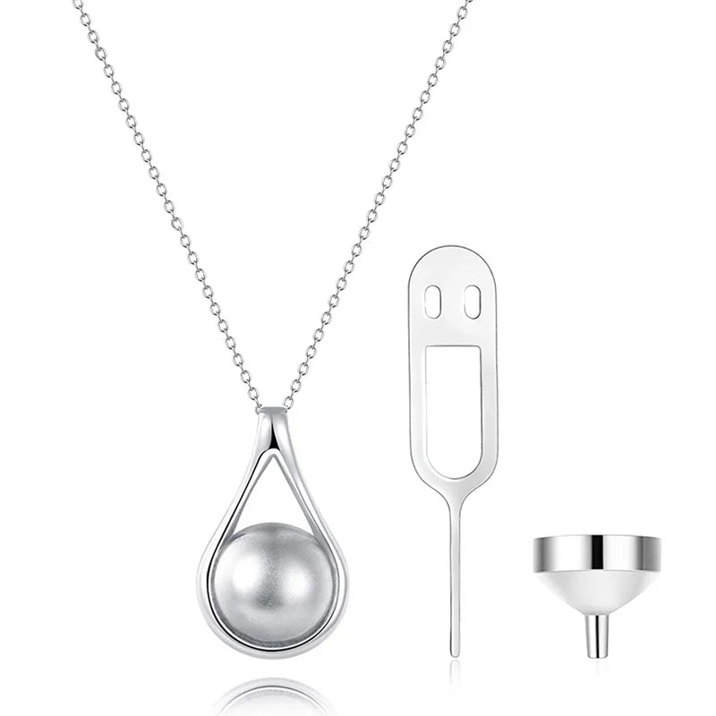 Sterling Silver teardrop cremation necklace with pearl center shown with chain, filling pin, and funnel for ashes.